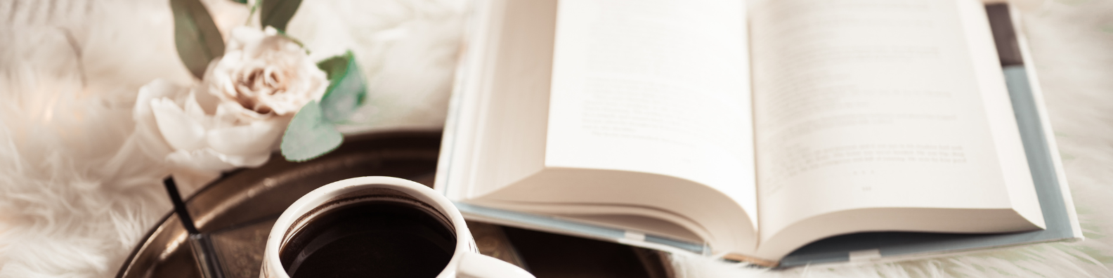 Discover more about my book - image shows a book, lying open on a table, next to some pale pink tea roses and a cup of coffee
